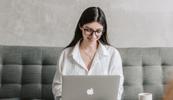 Woman smiles while researching work from home healthcare jobs on her laptop