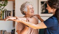A female physical therapist helps an older female patient by using SimplePractice physical therapy goals examples