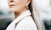 A close up of a woman in her fifties looking over her shoulder.