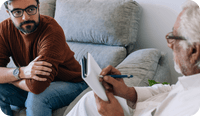 A client sits on the couch with his therapist who offers Medicare for mental health services