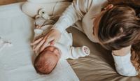 A mother bonding with her baby, postpartum. Coping with and addressing postpartum mood disorders, or other mental health concerns, is key to the new parents' and baby's health.