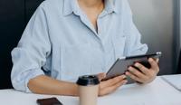 An occupational therapist (OT) private practice owner uses their iPad to find resources.