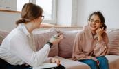 A female therapist conducts a psychotherapy session with a female client sitting on a couch, psychotherapy is one of the top CPT codes
