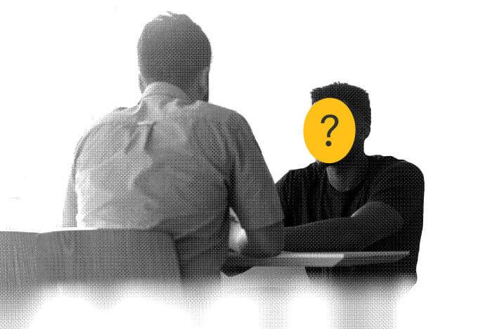 Two men at a table, one anonomized discuss the difference between a therapist and life coach