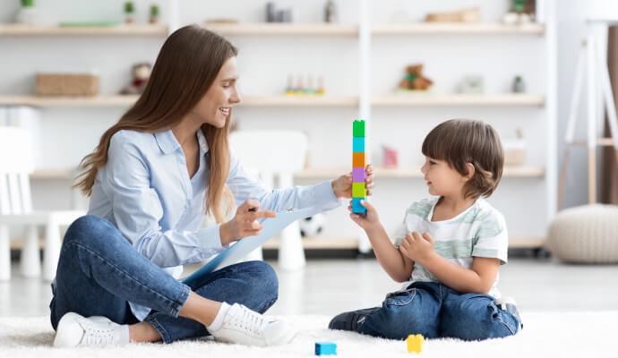 A child therapy client is using blocks in a play therapy session with a female therapist
