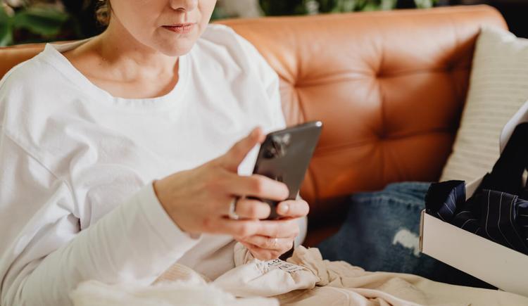 A female therapist uses her phone to read an article on the psychology of procrastination