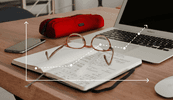 Outline of graph over desk with glasses, phone, notebook, and computer.