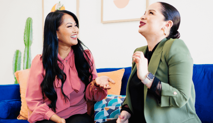Two women of color who are therapists sit on the couch together and discuss mentorship