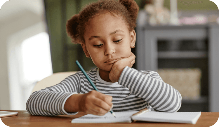 A child sits at a desk with her pencil and fills out the OWLs test