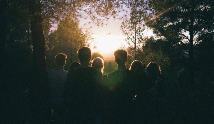 A substance use disorder treatment group watching the sunrise in the woods as part of their treatment