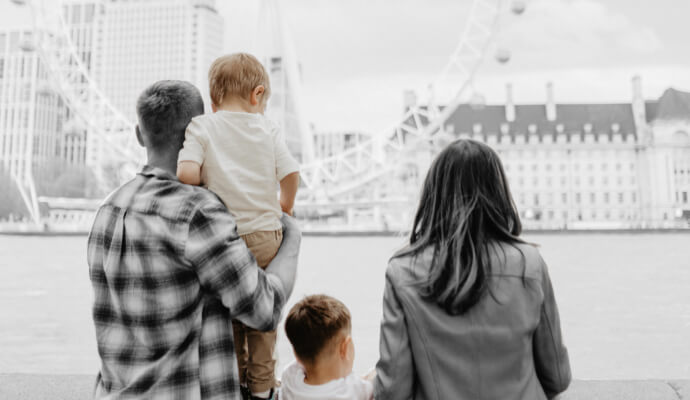 A family stands looking over a river.