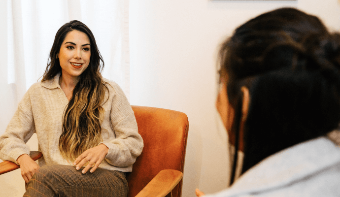 A female therapist talks with her client about different ways to pay for therapy that aren't insurance.