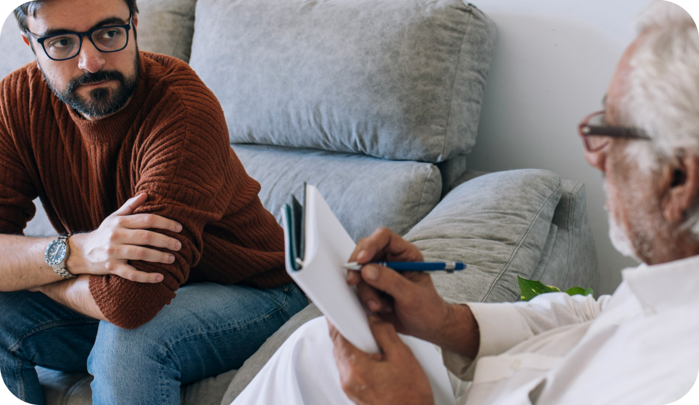 A client sits on the couch with his therapist who offers Medicare for mental health services