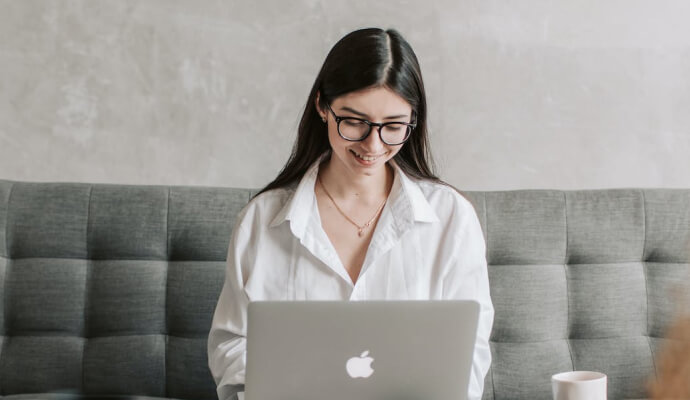 Woman smiles while researching work from home healthcare jobs on her laptop