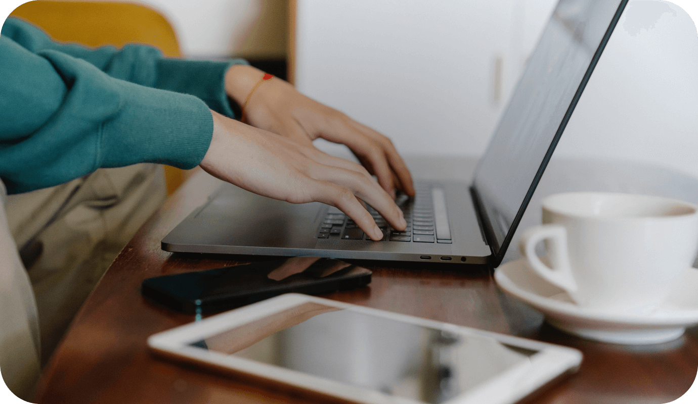 A therapist types on a laptop wondering about what it means to be HIPAA compliant as a therapist