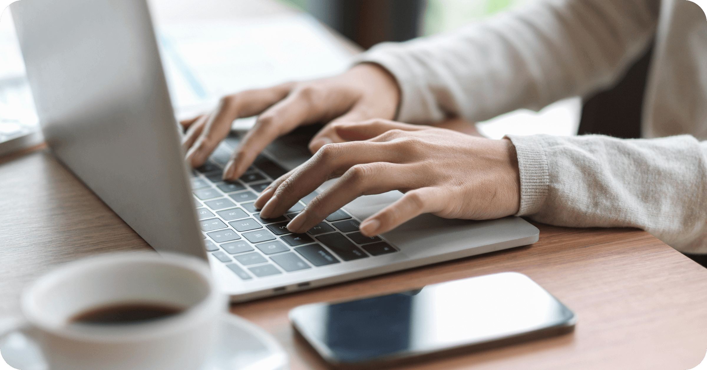 Close up of a person's hands on a computer searching for electronic soap note software, features to look for & how to transition from paper
