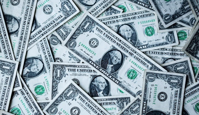pile of U.S. dollars representing difference between costs vs investments