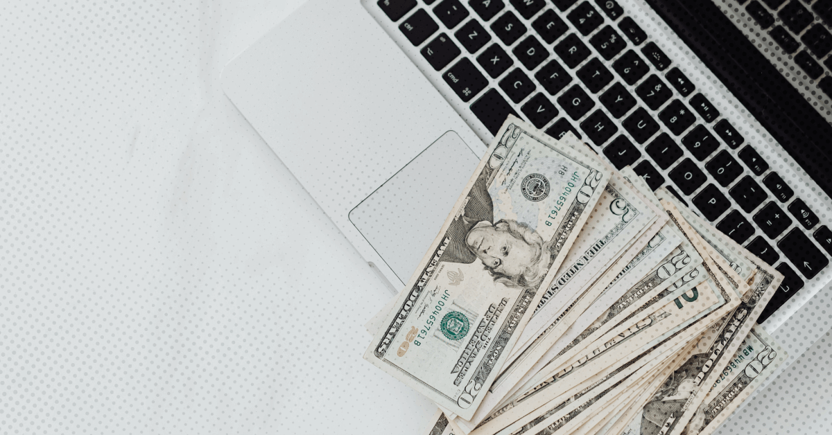 Laptop and money that represents a therapist working on a good faith estimate based on the no surprise act
